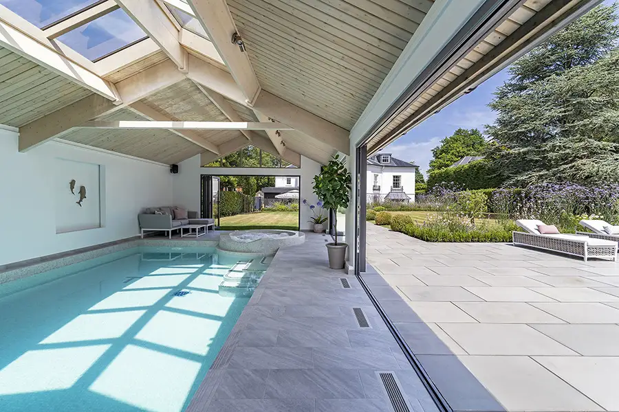 How Indoor Pools Stay Comfortable Year-Round Indoor pool with bifold doors all open